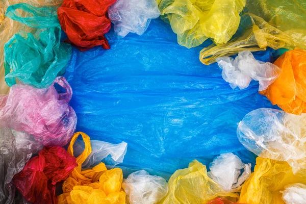 Het Grenskader Van Veelkleurige Plastic Zakken Blauwe Achtergrond Lege Ruimte — Stockfoto