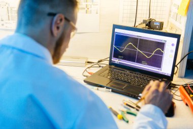 Elektronik araştırma atölyesinde çalışan adam.