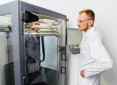 3D yazıcı yakışıklı erkek operatör büyük boy makine ile çalışıyor