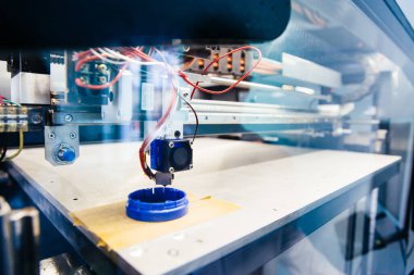 3D yazıcı platformunda taze basılmış mavi plastik detay
