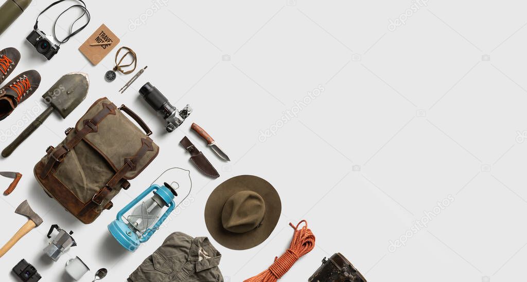 Top view of hiking and camping items arranged on abstract white background. Flat lay with copy space.