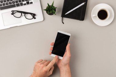 Modern ofis masasında mobil uygulama kullanan erkek eller düz yatıyordu