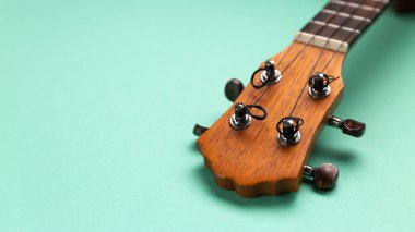 Ukulele başlığının yakın görüntüsü. Cyan arkaplan kopyalama alanı.