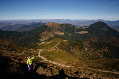 Fremale yürüyüşçüsü dağlarda dikiliyor ve nefes kesici manzarayı seviyor. Doğal resimsel Karpatya manzarası.