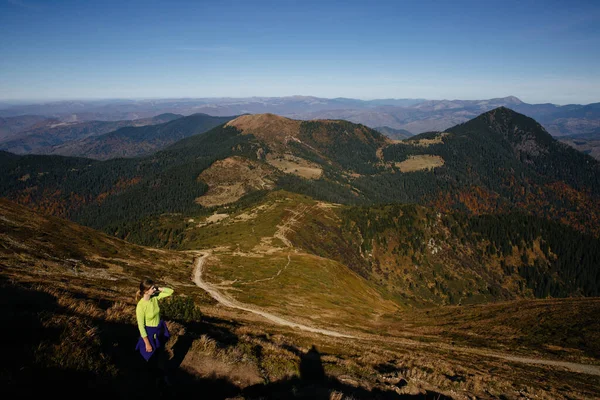 Fremale yürüyüşçüsü dağlarda dikiliyor ve nefes kesici manzarayı seviyor. Doğal resimsel Karpatya manzarası.