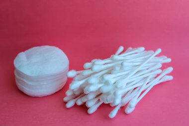 Pamuk tomurcukları ve pamuk tamponlarla pembe bir arka plan üzerinde