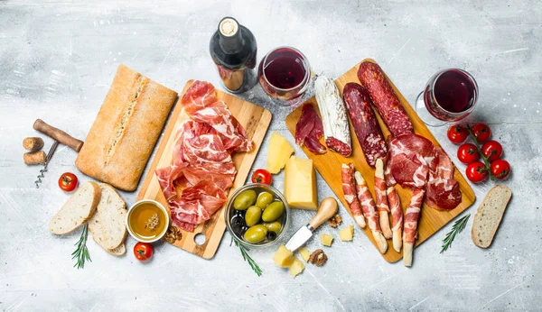 Antipasto background. Different Italian snacks with red wine.