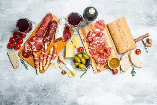 Antipasto background. Different Italian snacks with red wine.