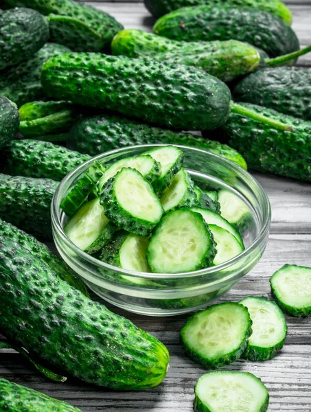 Whole cucumbers and cucumber slices in the bowl.