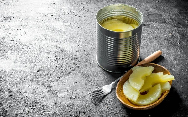 Canned pineapples on a plate with a fork.