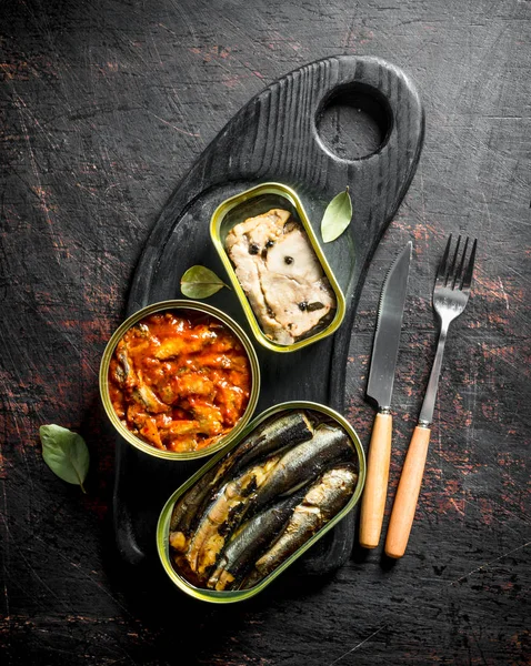 Canned fish in cans on a cutting Board.