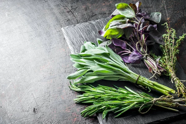 Fresh herbs. Salvia, thyme, rosemary and Basil on a stone Board.