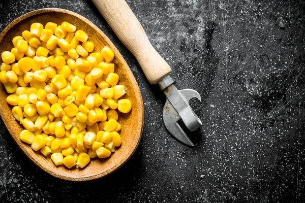 Canned corn on a plate with a can opener.