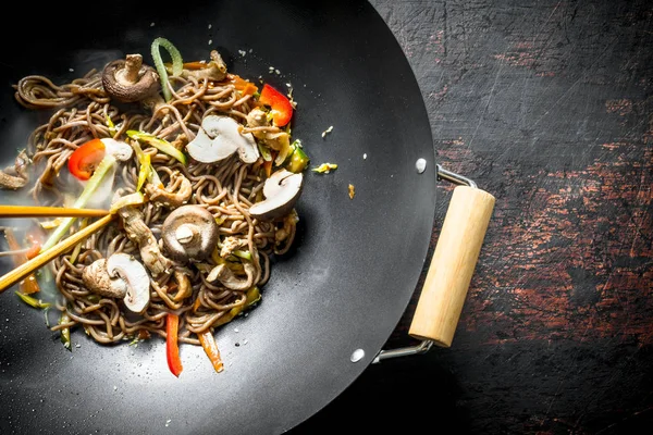 Hot Asian soba noodles with vegetables, mushrooms and sauce.