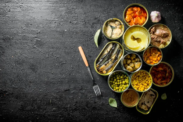 Open cans of mushrooms, pineapples, corn and canned fish.