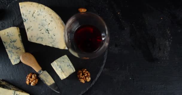 Sýr brie na kameni Deska se sklenicí vína a vlašských ořechů.