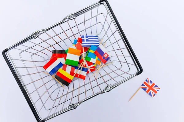 Brexit Concept - European union country flags in a mini wire shopping basket with a Union Jack Flag on it's own on the floor