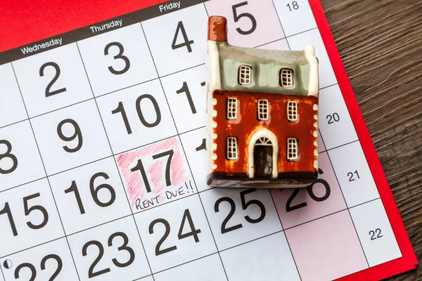 Miniature house with rent due written on a calendar page