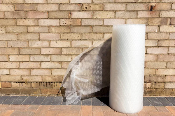 Large roll of bubble wrap against a brick wall