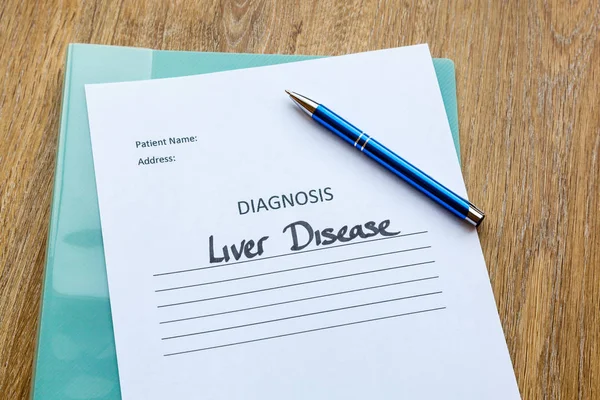 Liver disease diagnosis written on paper with a folder and pen.