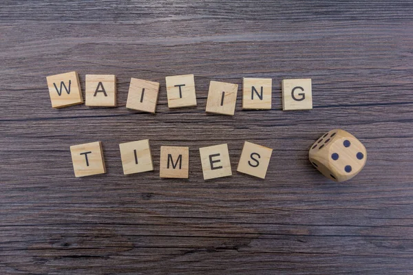Waiting Times Gamble - The word \'waiting times\' alongside a dice