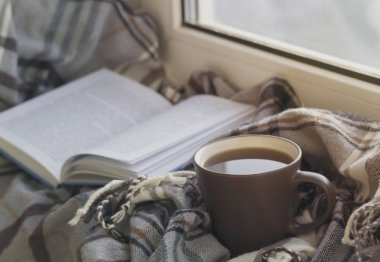 Kupası, kitap, gri kareli pencere eşiğinde. Yakın çekim