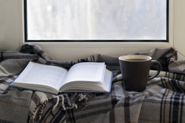 Kupası, kitap, gri kareli pencere eşiğinde. Yakın çekim