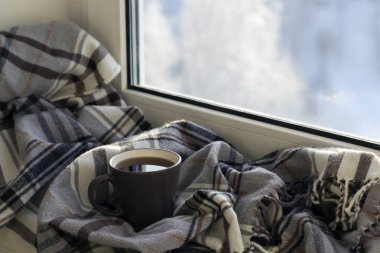 Kupası, kitap, gri kareli pencere eşiğinde. Yakın çekim