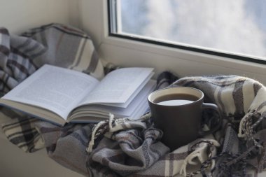 Kupası, kitap, gri kareli ve kitap beyaz pencere eşiğinde. Yakın çekim