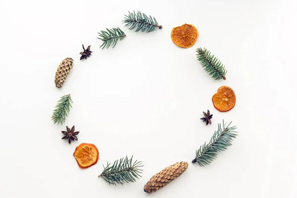 ペーパー クラフト 乾燥オレンジやマンダリン 星アニス シナモン 松ぼっくりでクリスマス プレゼントと丸いフレームは Fir の白い背景の枝します フラット横たわっていた — ストック写真