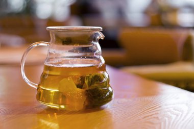 Cafe ahşap bir tabloda çay poşeti ile cam çaydanlık