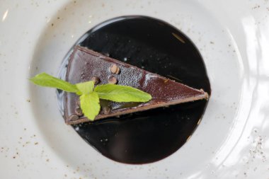 Çikolata Tepesi ve beyaz tabakta nane çikolatalı cheesecake yakın çekim