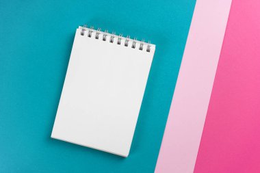 Modaya uygun turkuaz, pembe, morumsu kağıt üzerine not defteri. Çalışma alanı, çalışma konsepti. Model yap, boşluğu kopyala, üst görünüm, düz yat.