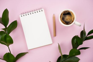 Not defteri, kahve, kalem, pembe arka planda bitki dalları. Çalışma alanı konsepti. Üst görünüm, kopyalama alanı, model, düz uzanma 