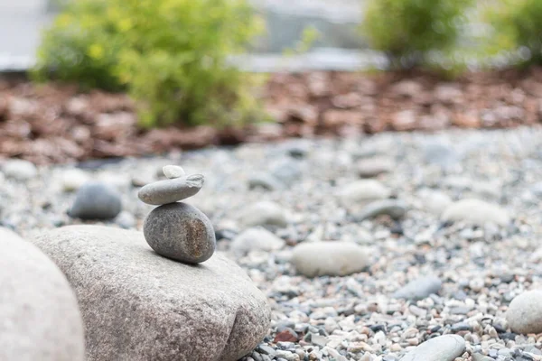 Pile of stones and green plants in japanese zen garden, copy space, close-up
