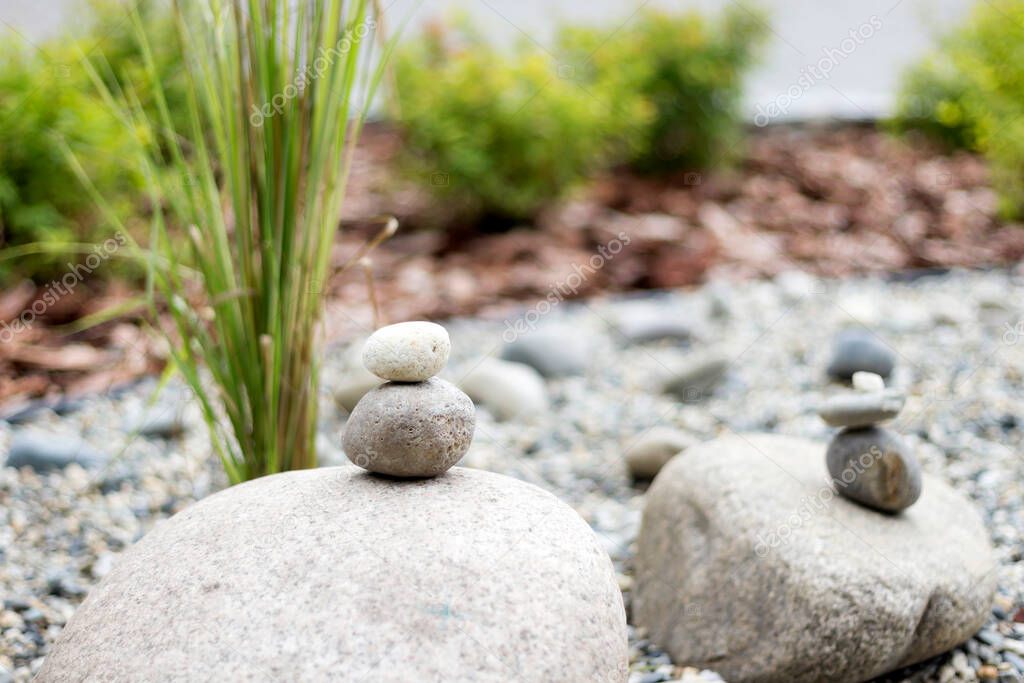 Pile of stones and green plants in japanese zen garden, copy space, close-up