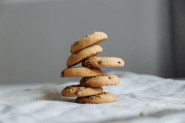 Gri tekstil arka planında kahverengi kurabiyeler üst üste