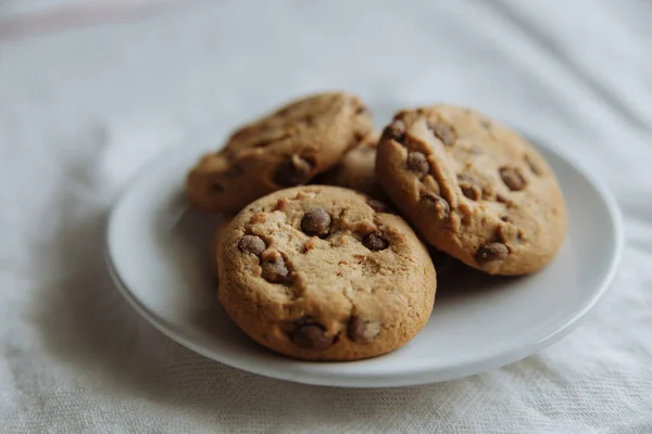 Brown cookies on the white plate in white textile — Stock Photo, Image