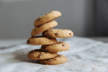 Gri tekstil arka planında kahverengi kurabiyeler üst üste