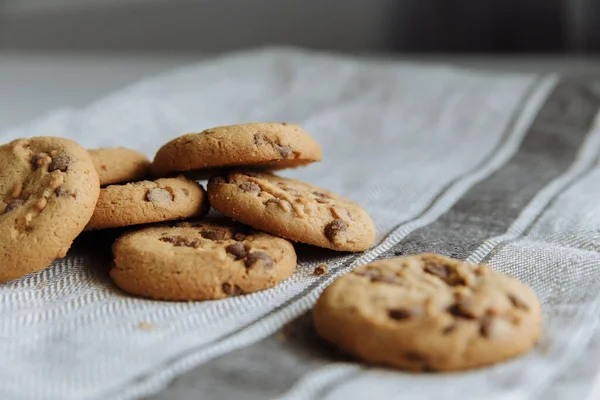 Açık gri tekstil arka planında kahverengi kurabiyeler — Stok fotoğraf