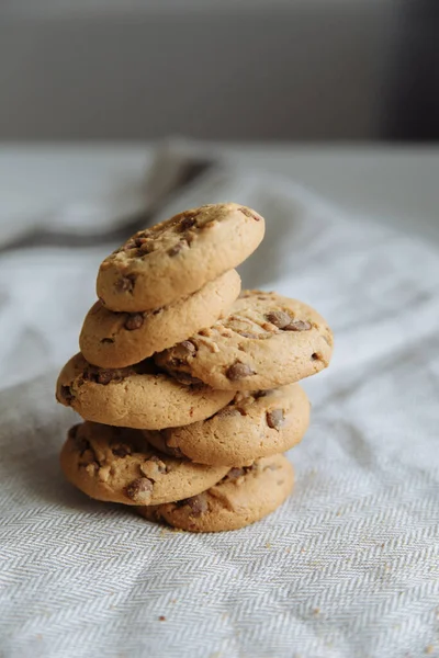 Brown cookies on top of each other on grey textile background — Stock Photo, Image