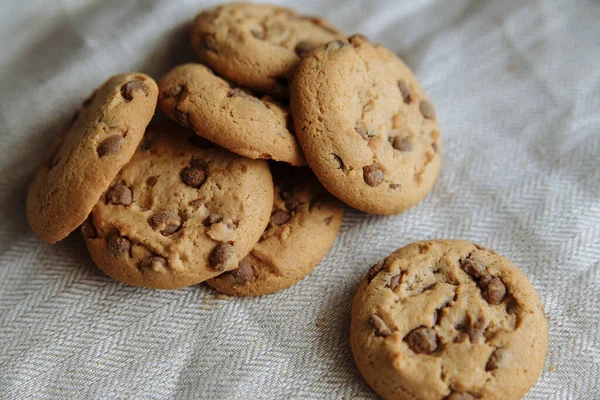 Biscoitos castanhos sobre o fundo têxtil cinza claro — Fotografia de Stock