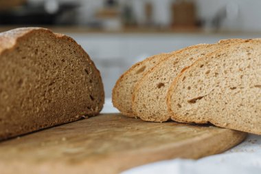 Beyaz bir masa örtüsünün üzerinde dilimlenmiş ekmek.