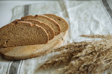 Beyaz bir masa örtüsünün üzerinde dilimlenmiş ekmek.