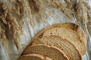 Beyaz bir masa örtüsünün üzerinde dilimlenmiş ekmek.