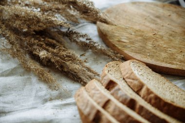 Beyaz bir masa örtüsünün üzerinde dilimlenmiş ekmek.