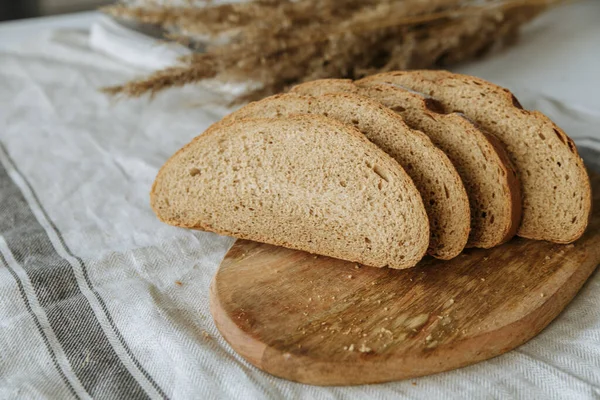Beyaz bir masa örtüsünün üzerinde dilimlenmiş ekmek.