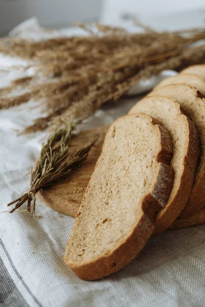 Sliced bread on a board on a white tablecloth — Stock Photo, Image