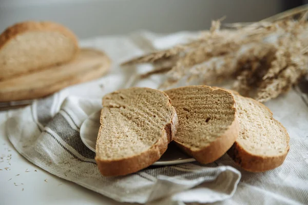 Sliced bread on a board on a white tablecloth — Stock Photo, Image