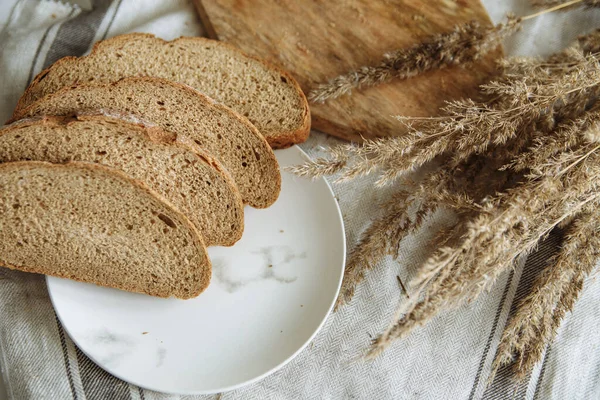Sliced bread on a board on a white tablecloth — Stock Photo, Image
